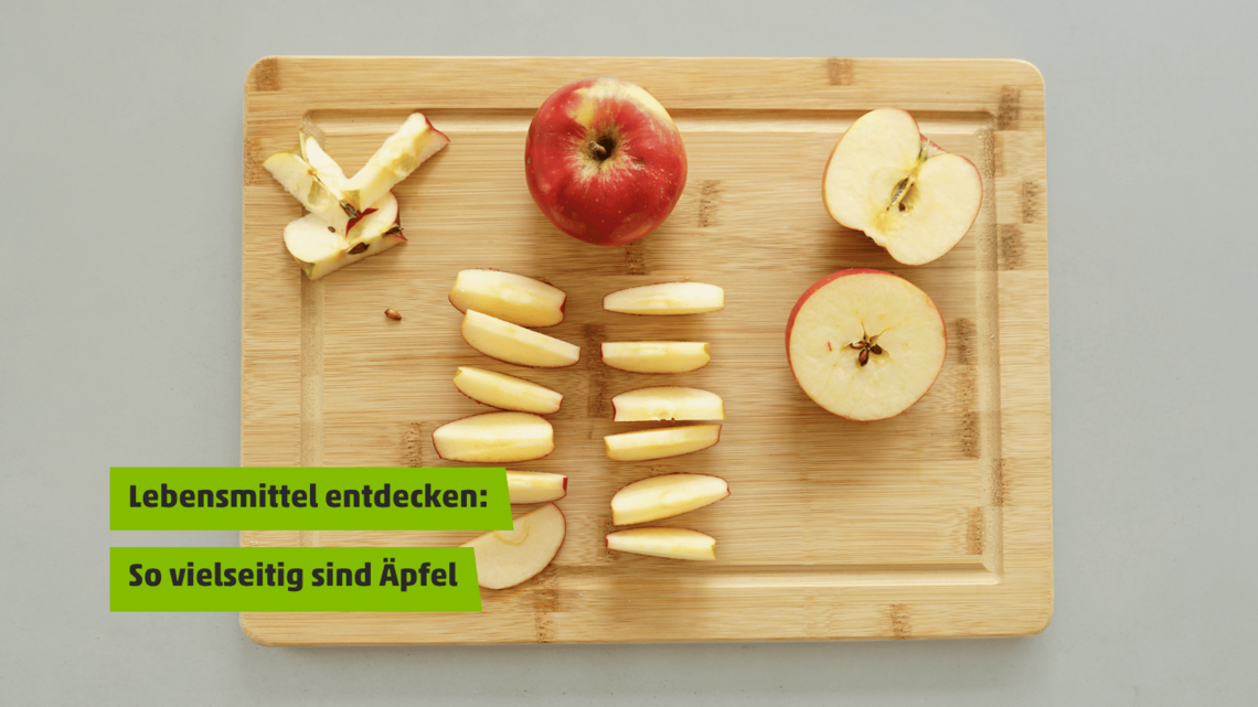 Ein ganzer Apfel und ein geschnittener Apfel auf einem Holzbrett