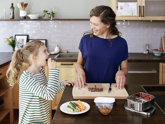Eine Frau und ein Kind beim Vorbereiten einer Brotdose