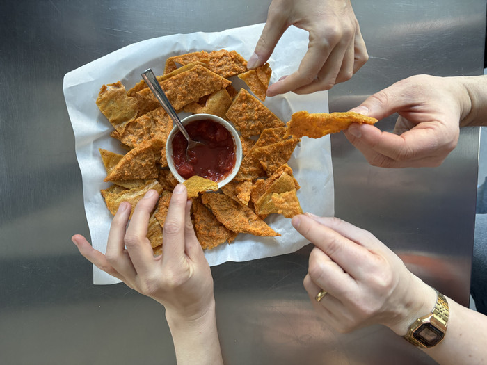 Foto: Sarah Wiener Stiftung Vier Hände greifen nach Linsenchips mit Dip
