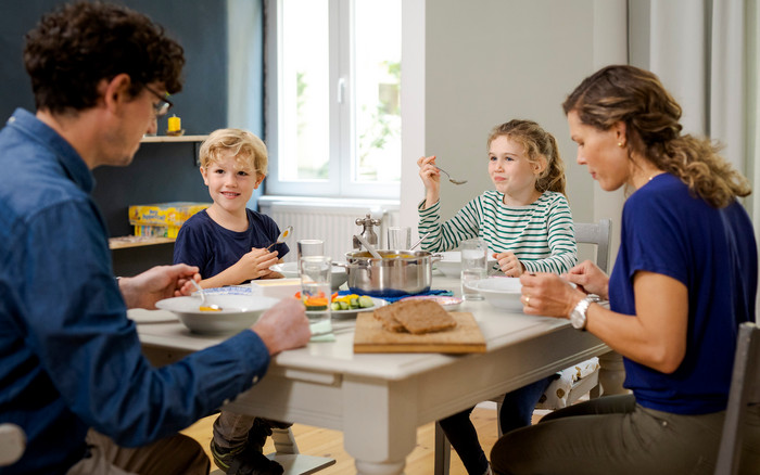 Foto: Sarah Wiener Stiftung | photothek Nach dem Kochen mit Kindern isst Familie gemeinsam am Esstisch.