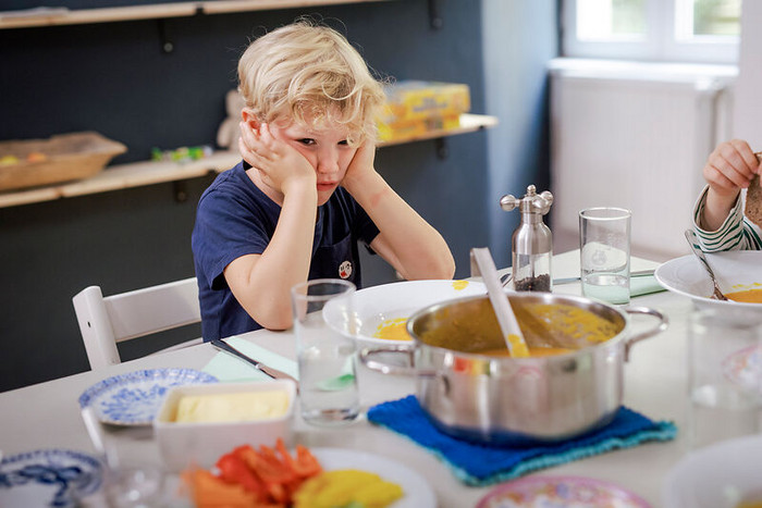 Junge sitzt am Küchentisch und will nicht weiteressen
