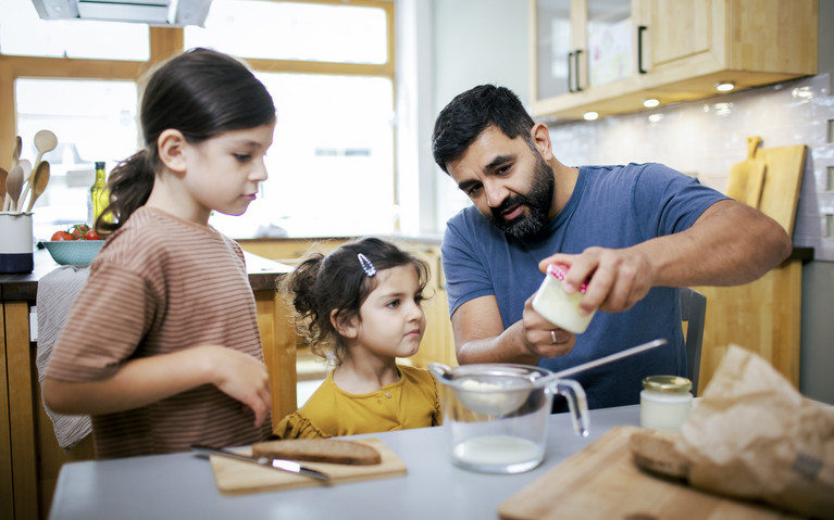 Foto: Sarah Wiener Stiftung | photothek Zwei Kinder und ein Erwachsener sehen sich ein Glas mit geschüttelter Butter an