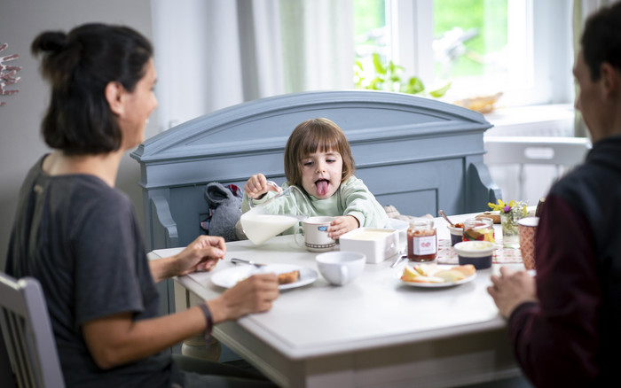Foto: Sarah Wiener Stiftung | photothek Ein kleines Kind gießt sich am Esstisch Milch