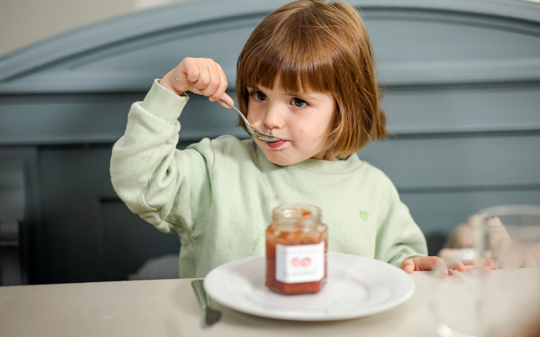 Kind liebt Süßigkeiten und will ständig Süßigkeiten. Kind isst Marmelade zum Frühstück.