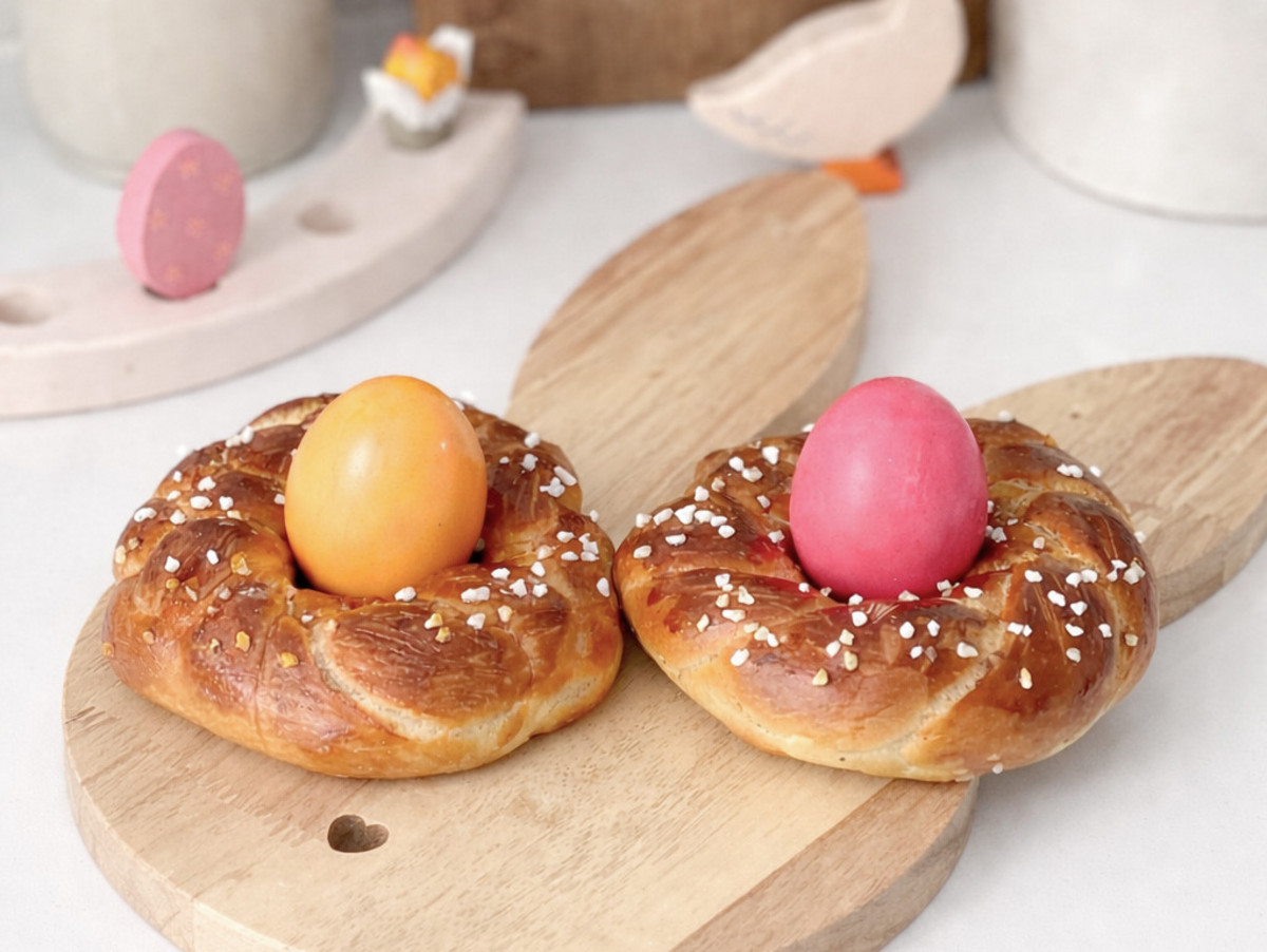 Zwei Hefeteignester mit einem orangefarbenen und einem rosa Ei