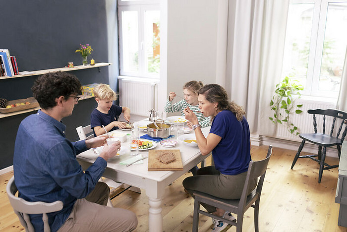 Eine Familie isst gemeinsam am Esstisch