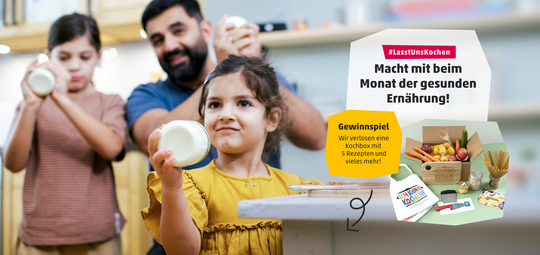 Zwei Kinder und ein Erwachsener schütteln Butter