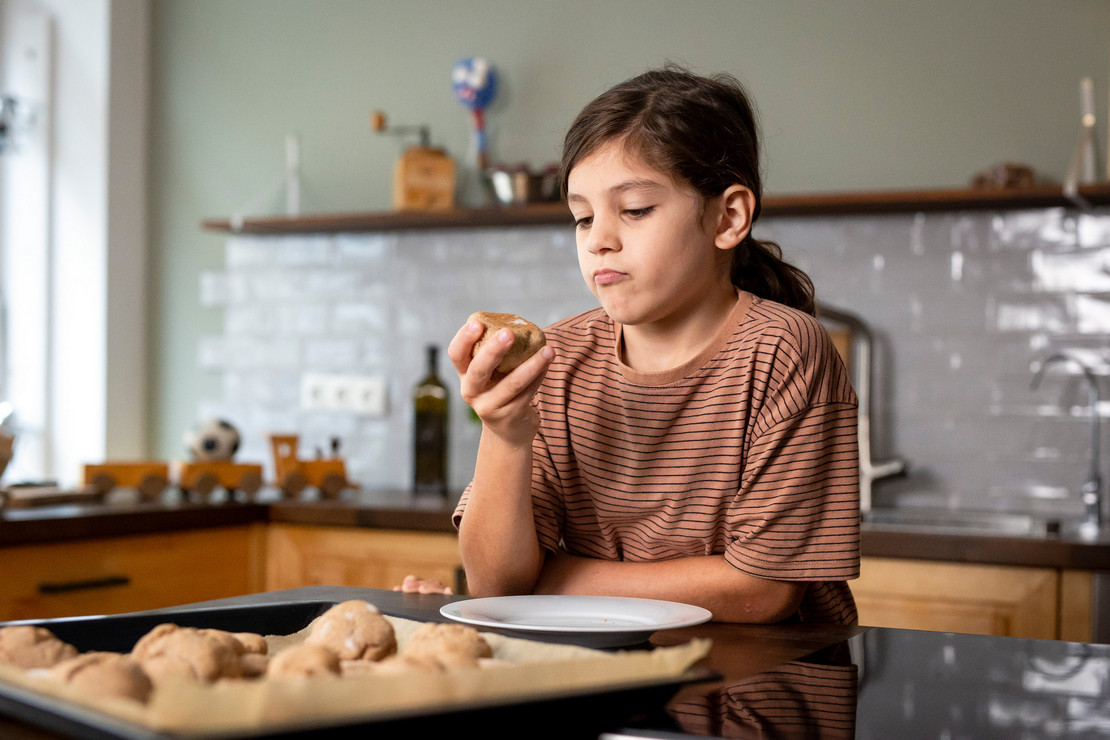 Mädchen beim Brötchen backen in der Küche